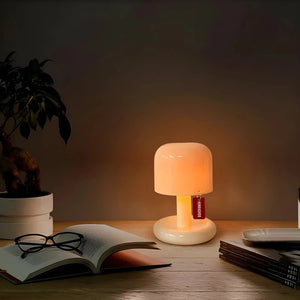 Glowing table lamp with a cylindrical shade and wooden base.