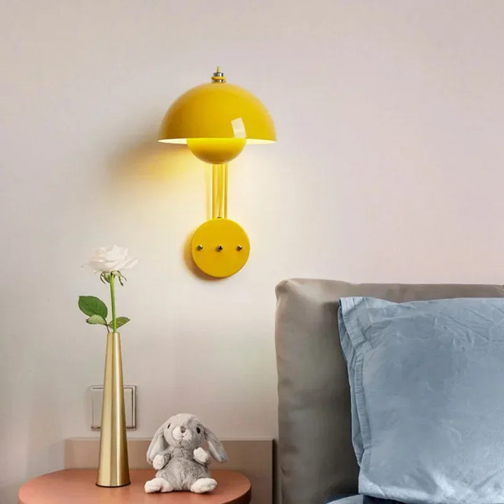 Bright yellow wall-mounted lamp with a dome-shaped shade and circular base.