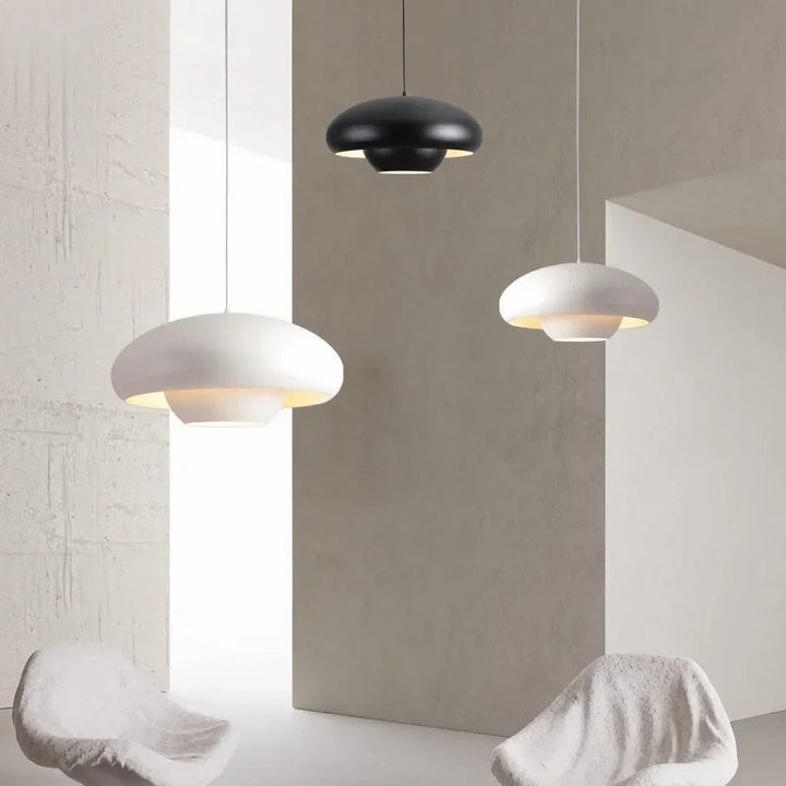 Modern pendant light fixtures with dome-shaped shades in black and white.