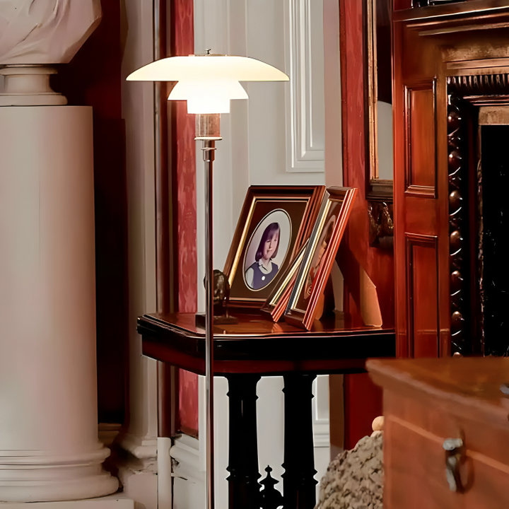 Modern table lamp with a white, saucer-shaped shade on a slender metal stand.