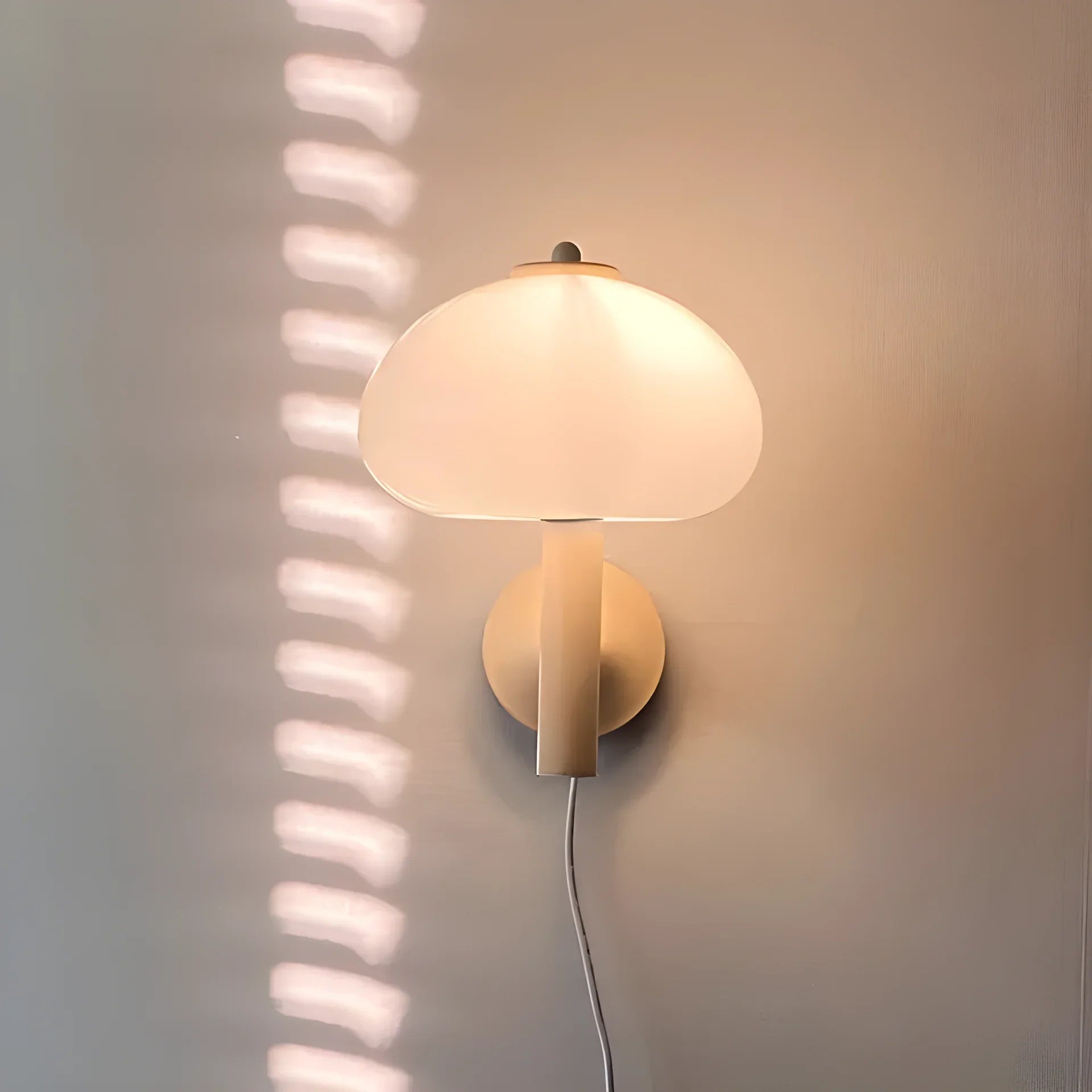 Mushroom-shaped wall sconce with a glowing dome shade.