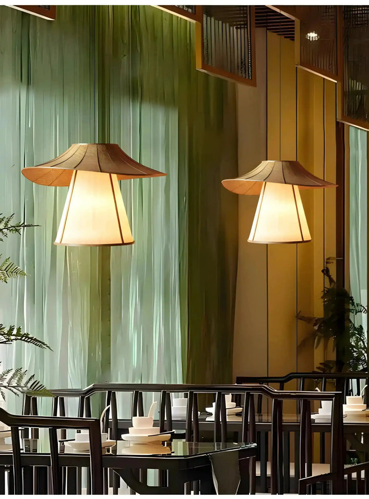 Pair of illuminated pendant lamps with wide, conical shades.