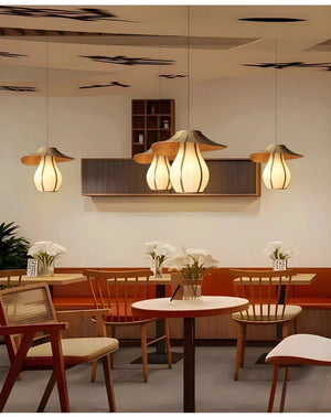 Pendant lights with petal-like shades hanging over a dining area.