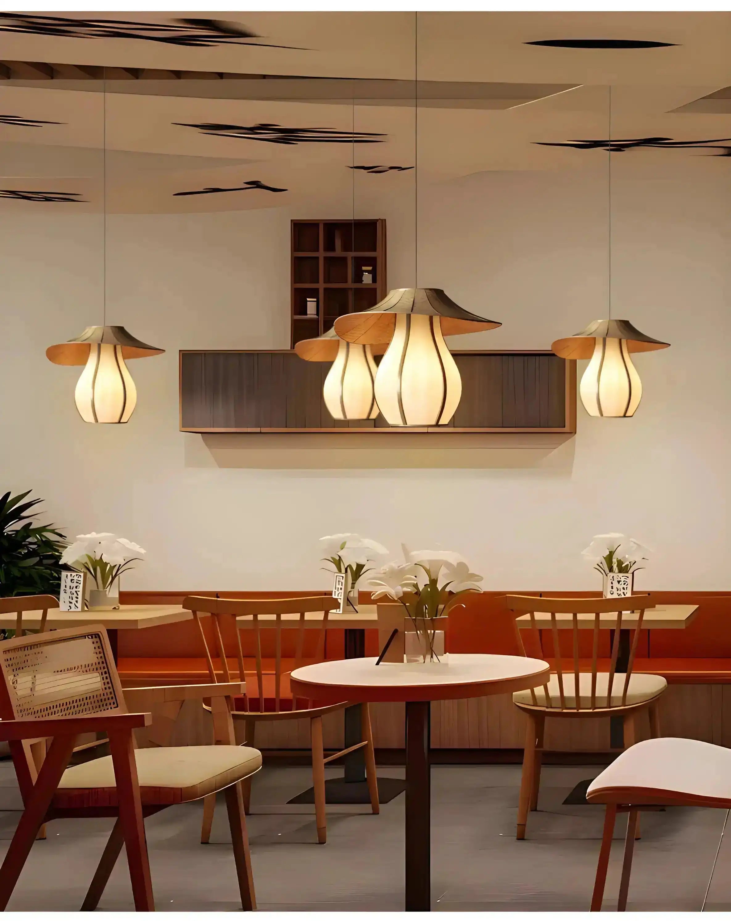 Pendant lights with petal-like shades hanging over a dining area.