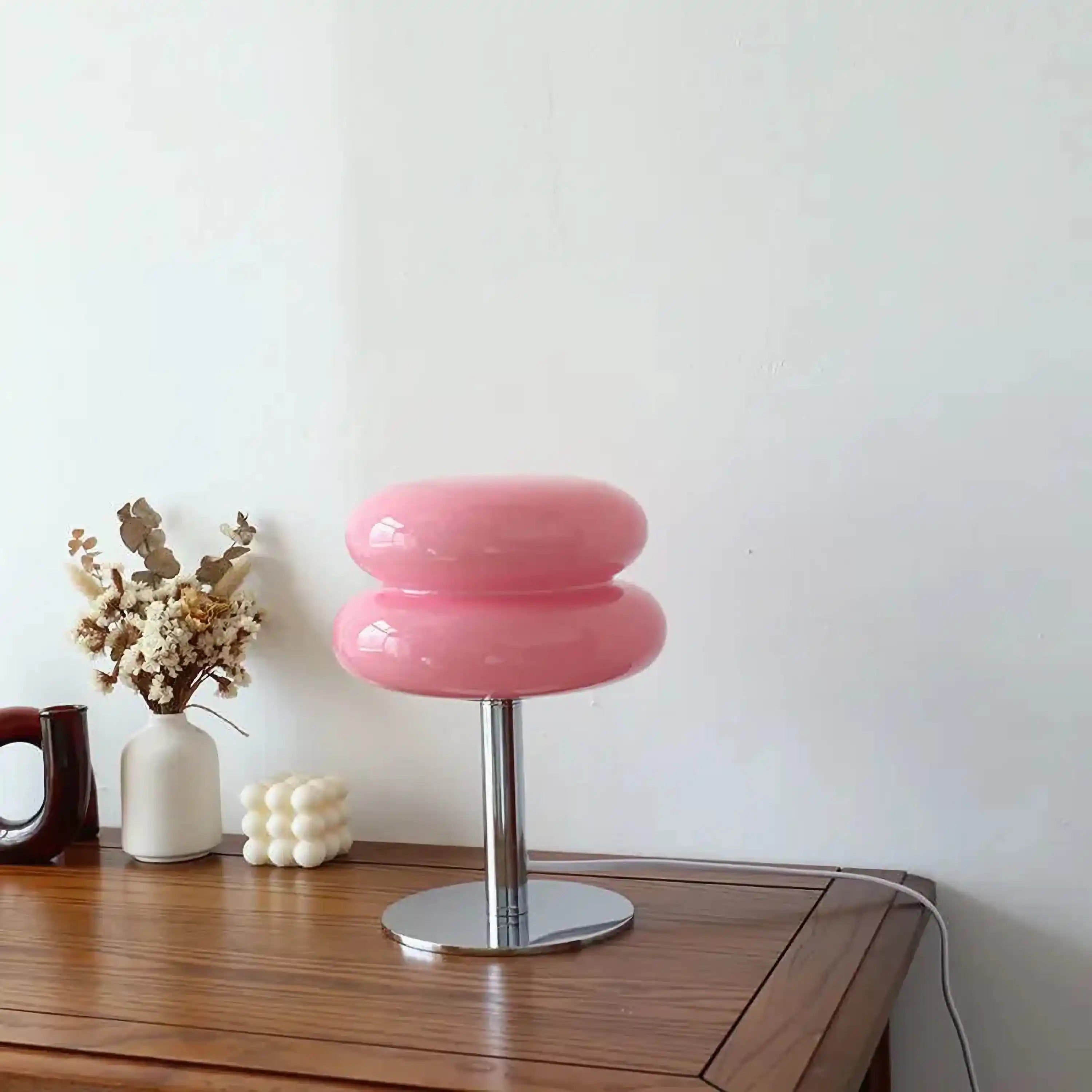 Pink, mushroom-shaped table lamp with a metal base.