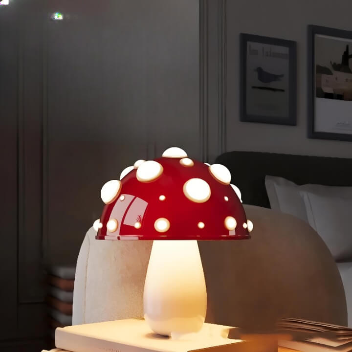 Red and white polka-dotted mushroom-shaped lamp emitting a warm glow.